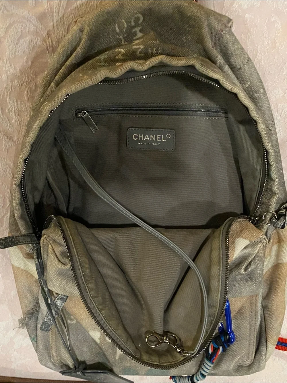 CHANEL Faded Beige Canvas Backpack with Multicolor Strap and Silver-Tone Charm